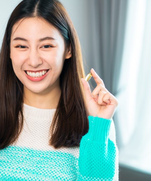 young beauty asian  Pregnant woman  holding vitamin pill isolated at home.healthcare and medical concept..