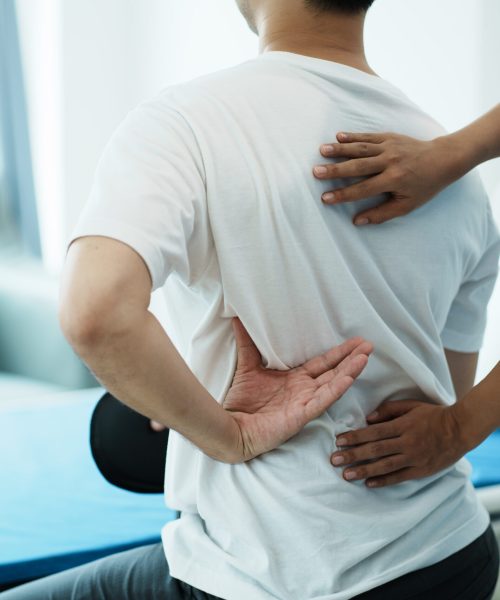 Doctor consulting with patient back problems physical therapy concept.